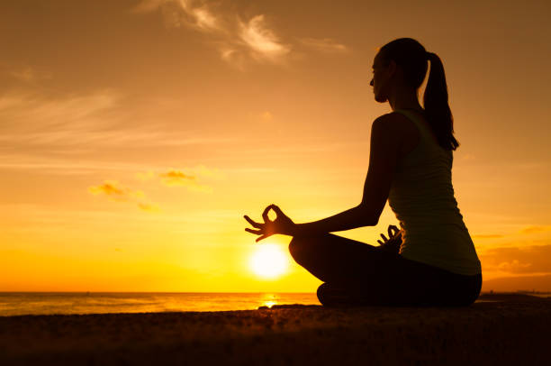 Woman doing meditation practice by the beach.